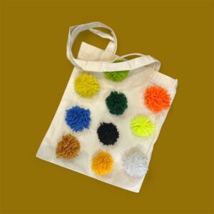 حقيبة كتف من القطن المتين مزينة يدويا بخيوط الصوف الملونة بتصميم تقليدي بسيط