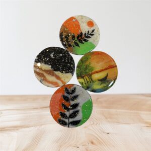 اربعة قطع من الخشب (قواعد الأكواب ) على شكل دائرة قطرها 10 سم مرسومة يدويا بأشكال الطبيعة ومطلية بمادة الريزن اللامع للحماية من بقع المشروبات الساخنة وحرارة الاكواب والخدوش