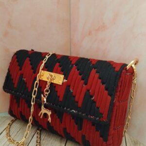 حقيبة نسائية مميزة باللون الاحمر الداكن والاسود مزودة بسلسلة ذهبية تناسب الحفلات والمناسبات